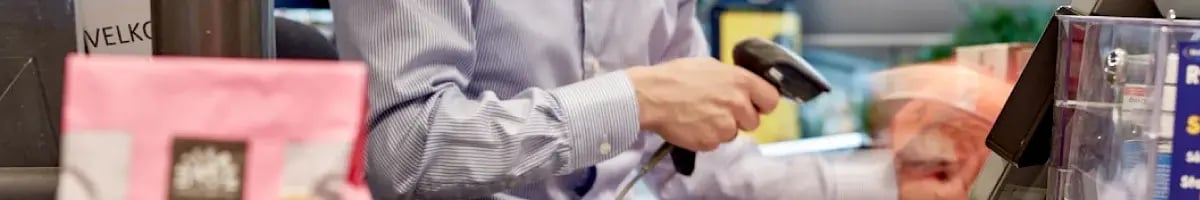 Retail cashier using a stationary POS scanner